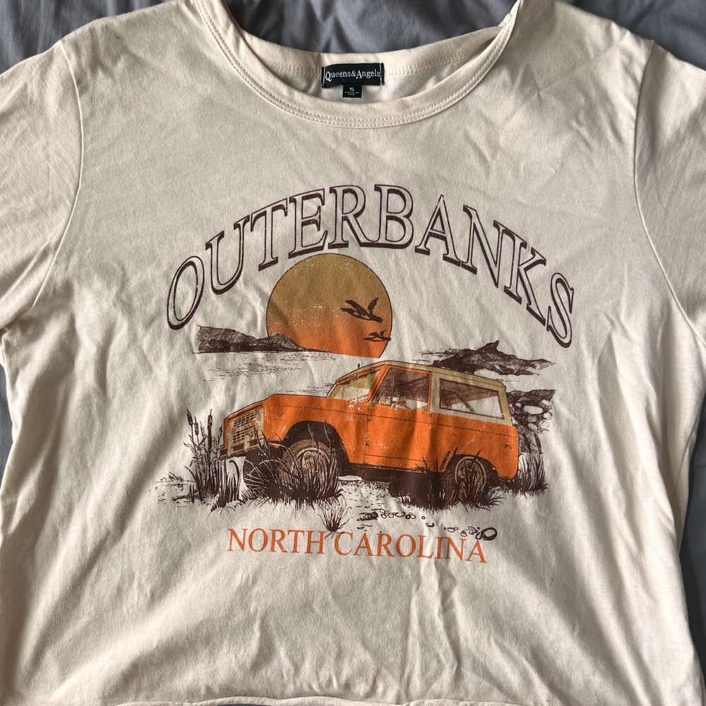 A women’s small with a cream/white background with a design on front.